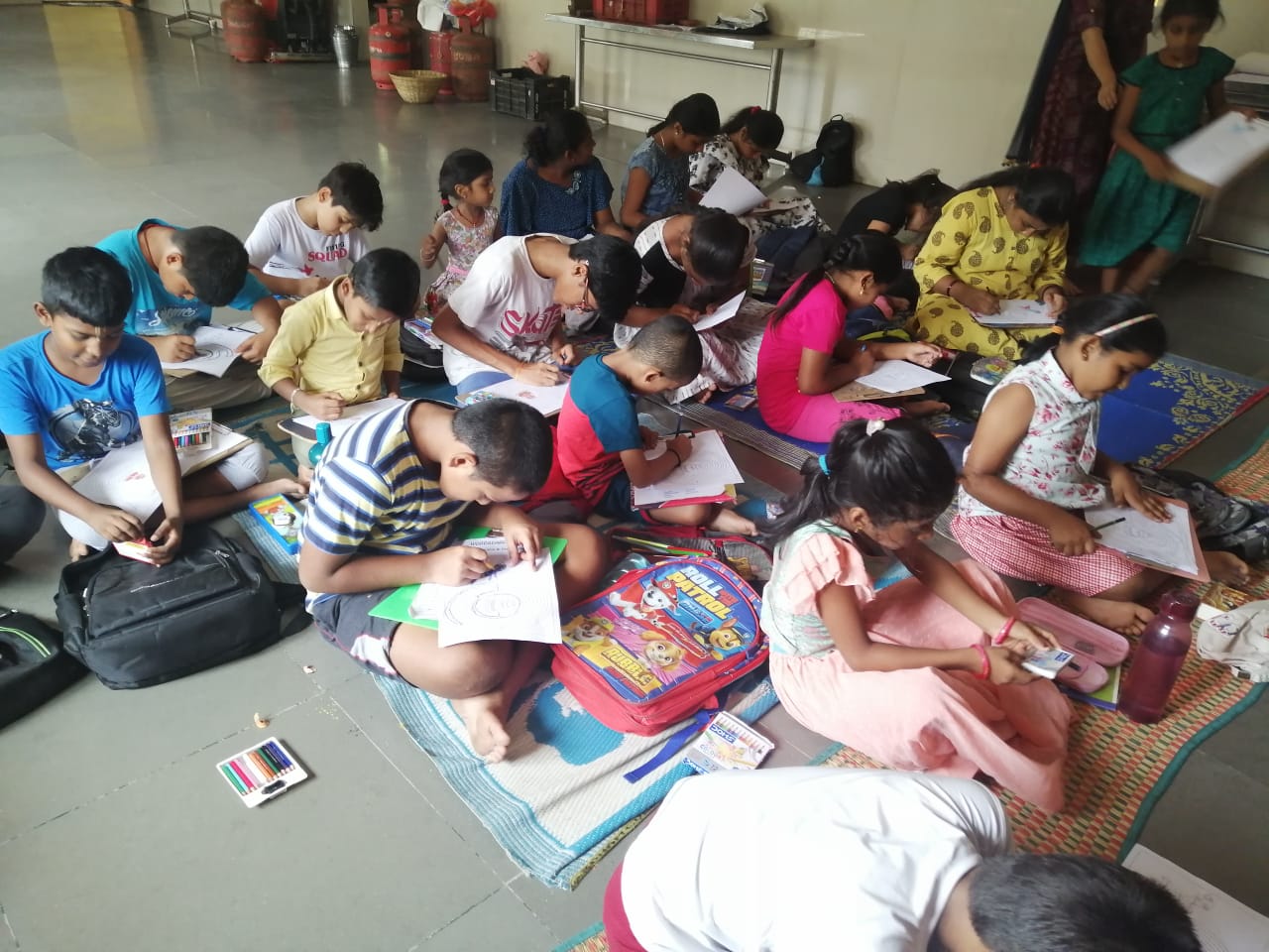 Gurukul children drawing together in the temple hall
