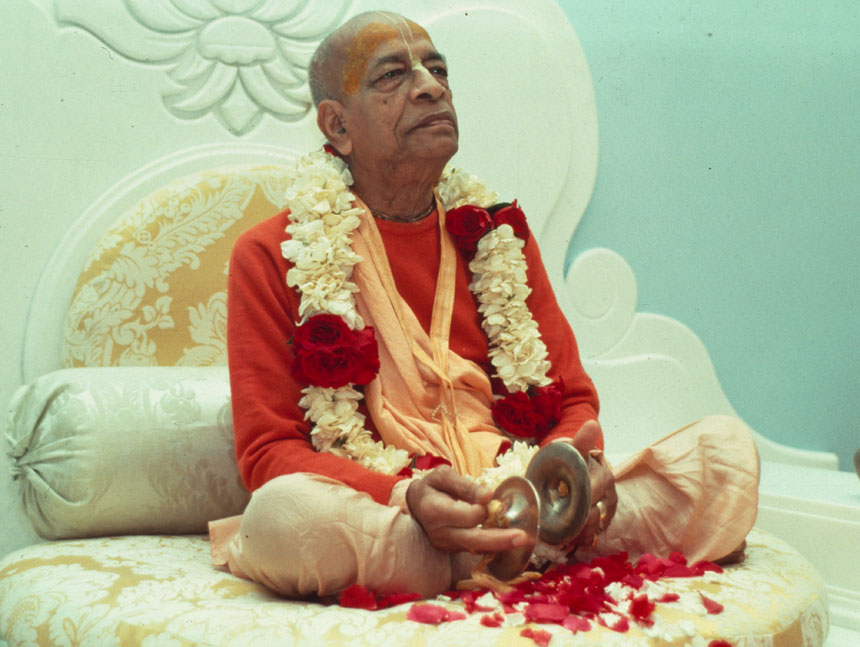 Srila Prabhupada seated with karatalas and a flower garland